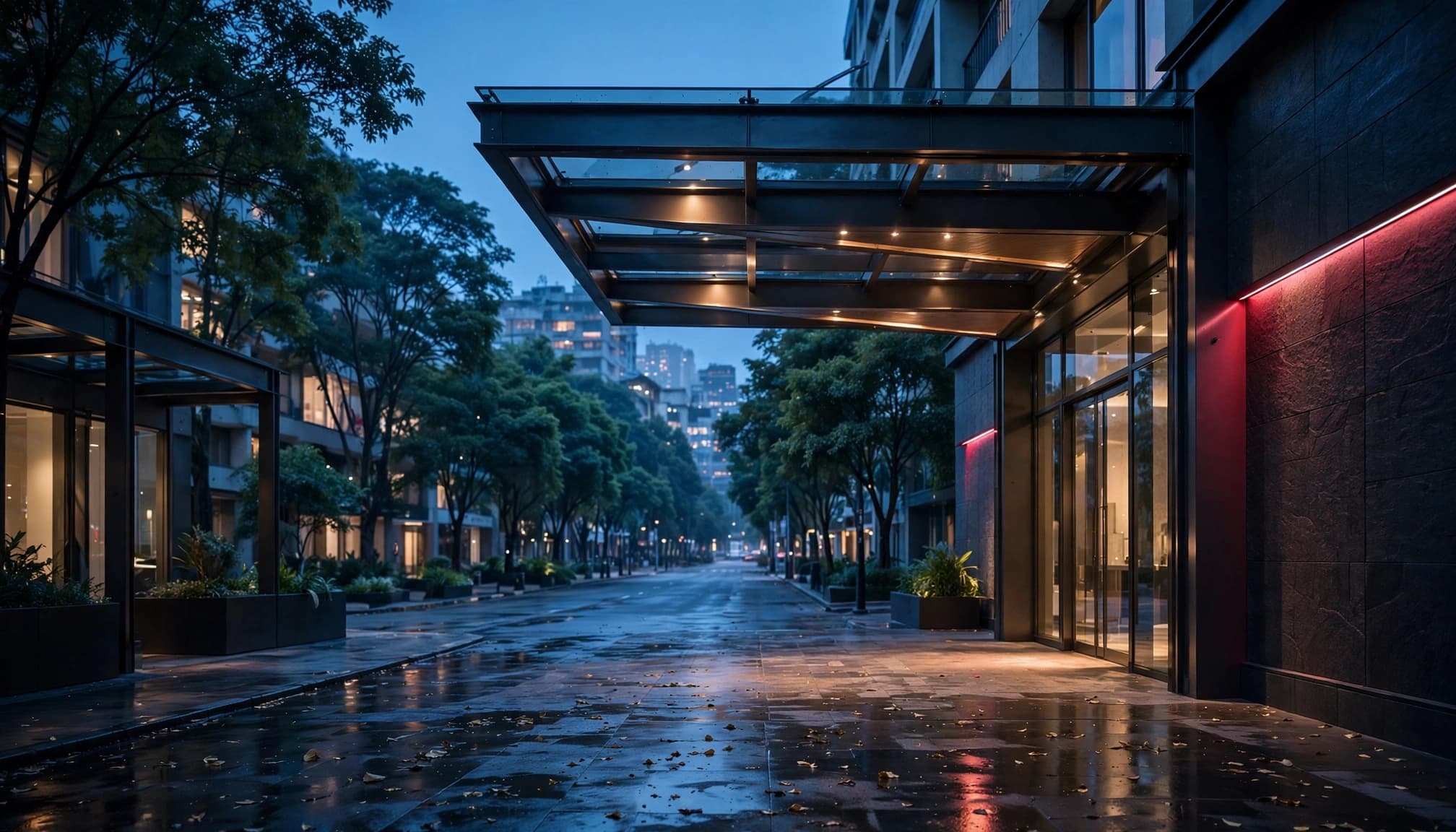 A quiet city street at blue hour viewed from outside a modern hotel entrance.